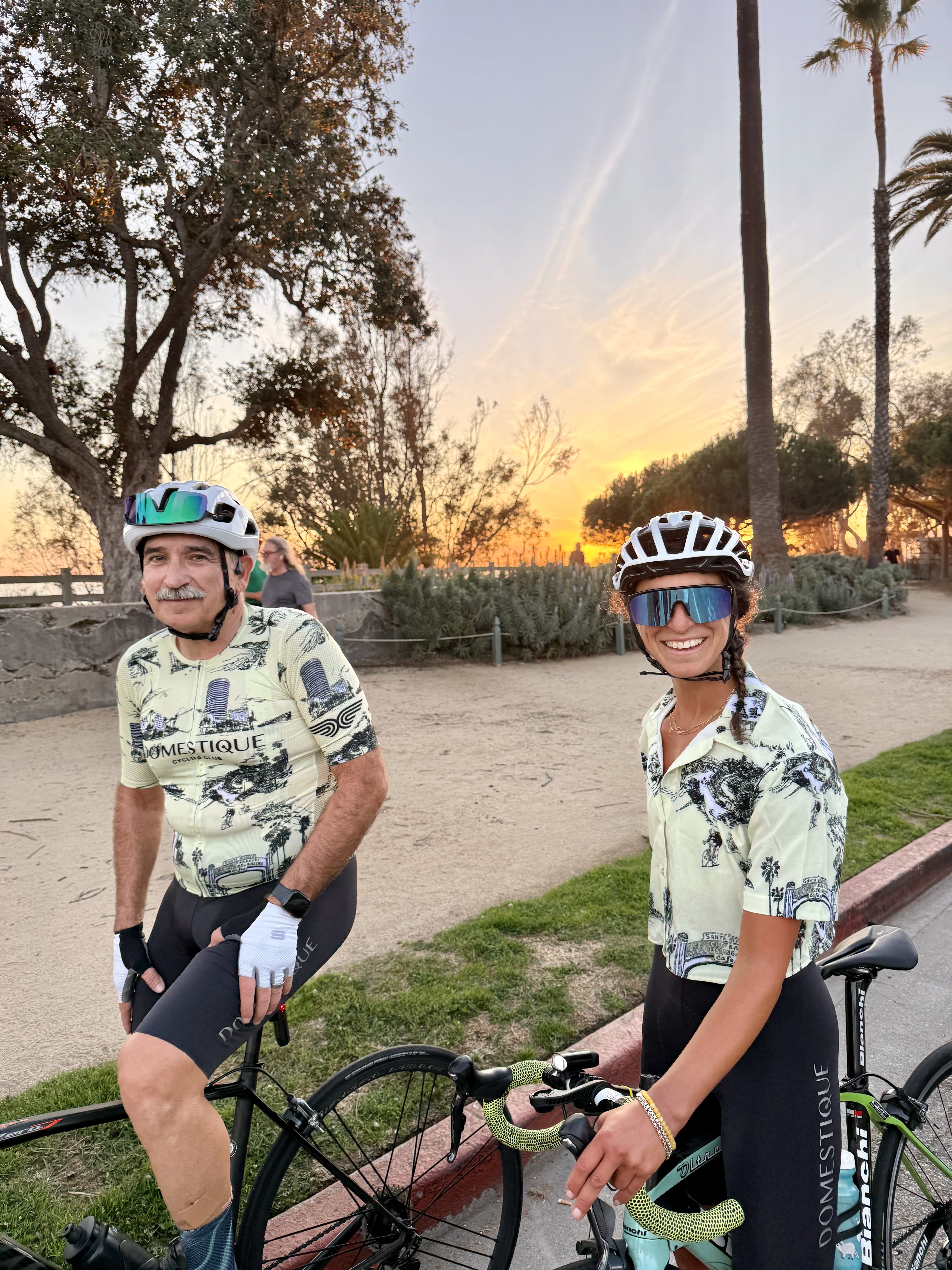 Two DCC members in the 2025 butter colorway kit at sunset on the Marina bike path