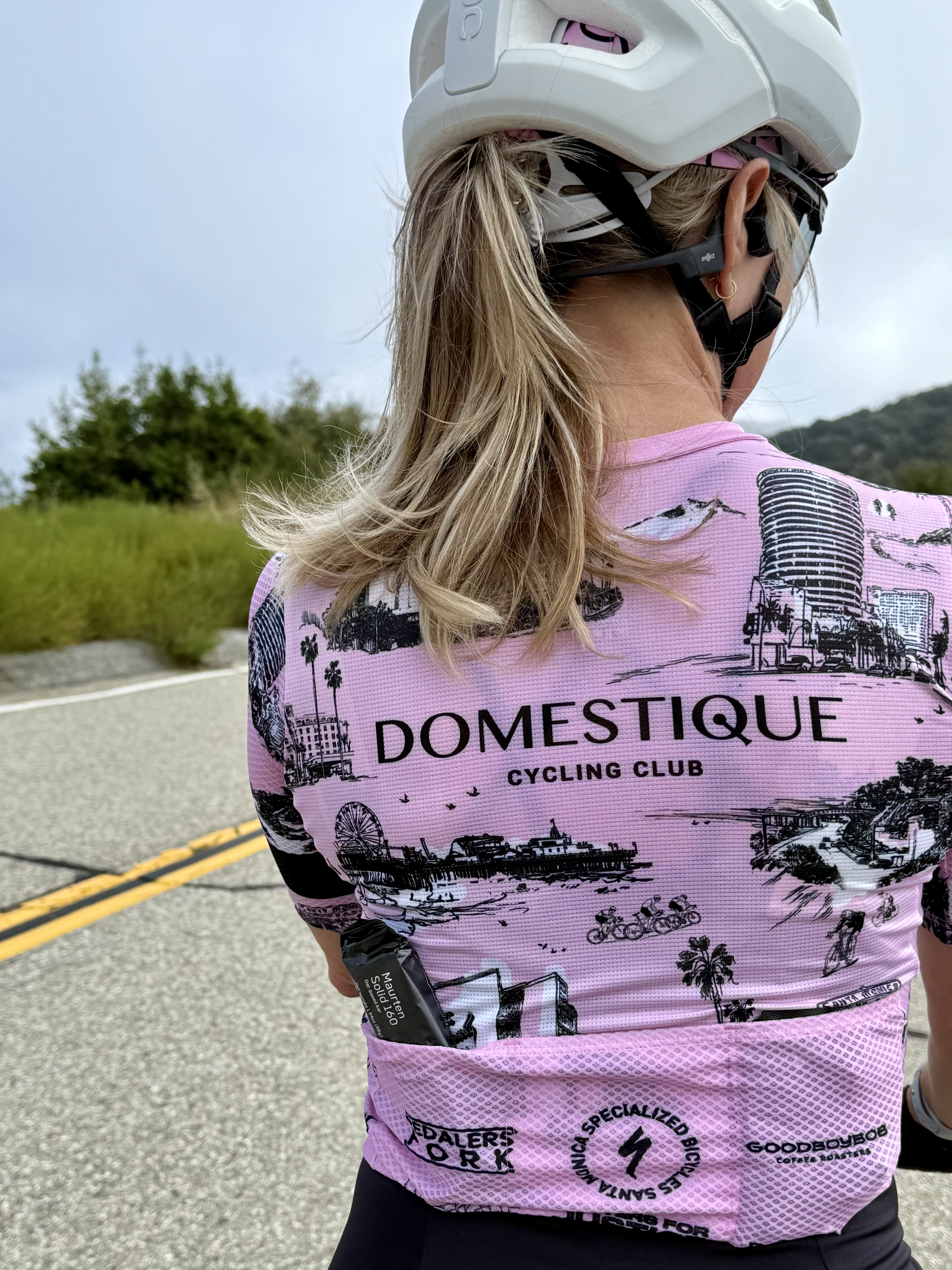 The back of a DCC rider in the club kit, partner logos printed across the jersey