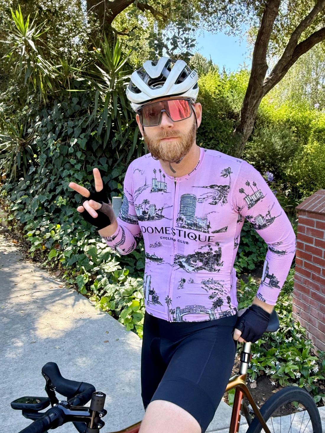A DCC ride leader in the pink Domestique jersey, throwing a peace sign