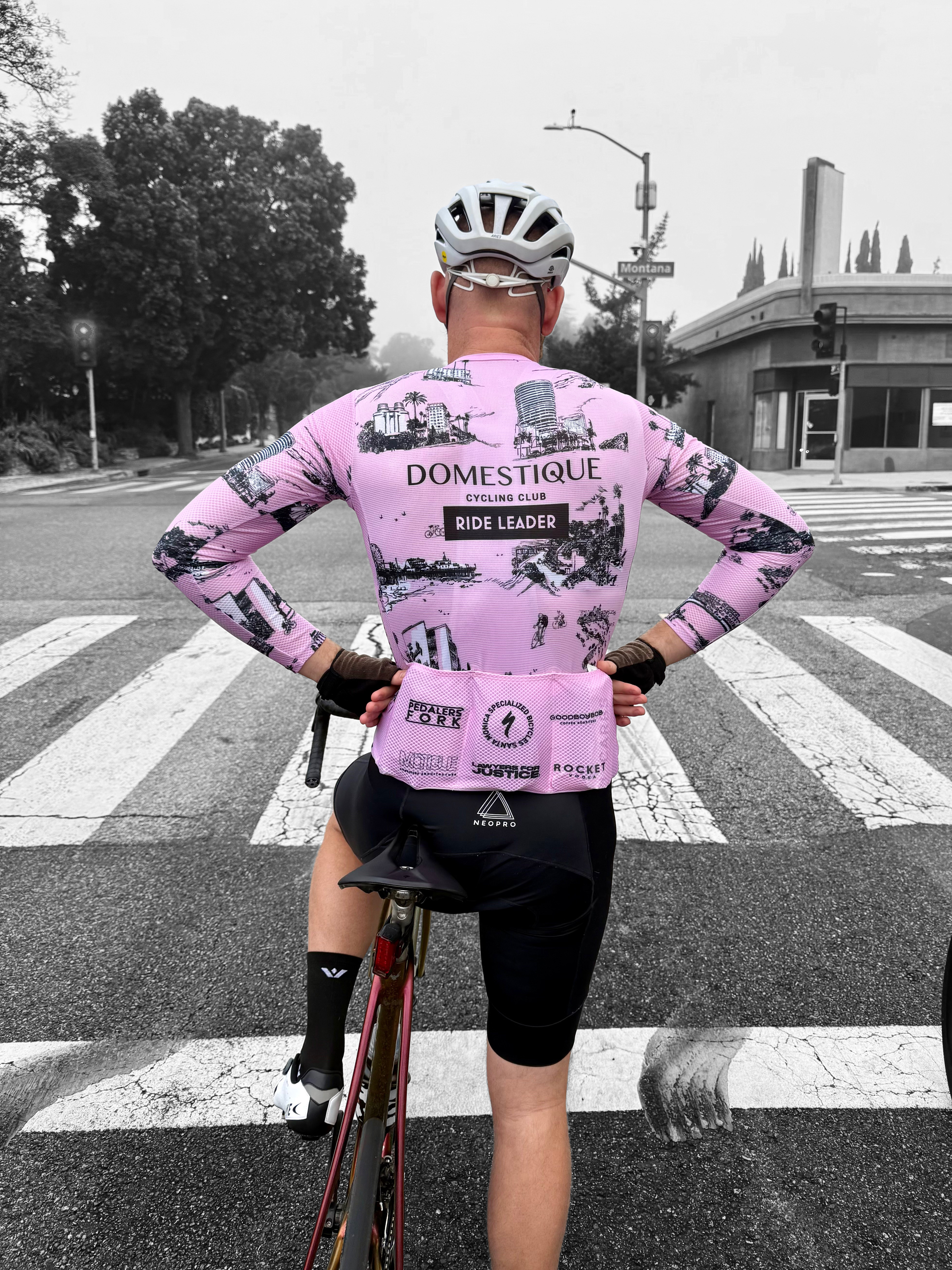 DCC ride leader at an intersection, RIDE LEADER patch visible on the back of the pink jersey